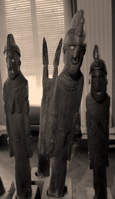 Photo by Suzi Richer. A few characters from the waka on display in the Ethnographic Museum. Left to right: second wife of the ‘hero’, ‘hero’, first wife of the ‘hero’, the shield on spears of the ‘hero’ are depicted behind them. ‘Hero’ was the term used in the display depiction.
